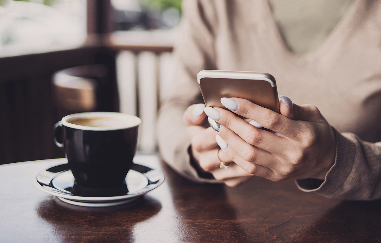 Girl using smart phone in coffee shop